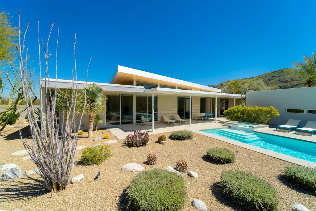 Jardín de cactus y piscina bajo el tejado volado