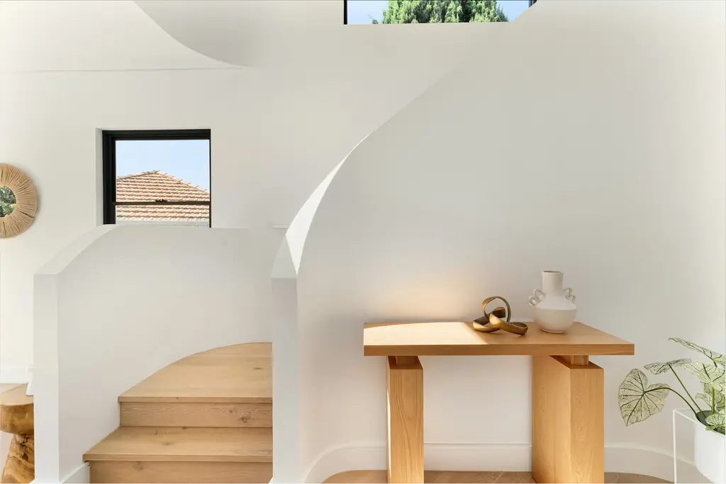 Escalera de madera junto a una pared curva