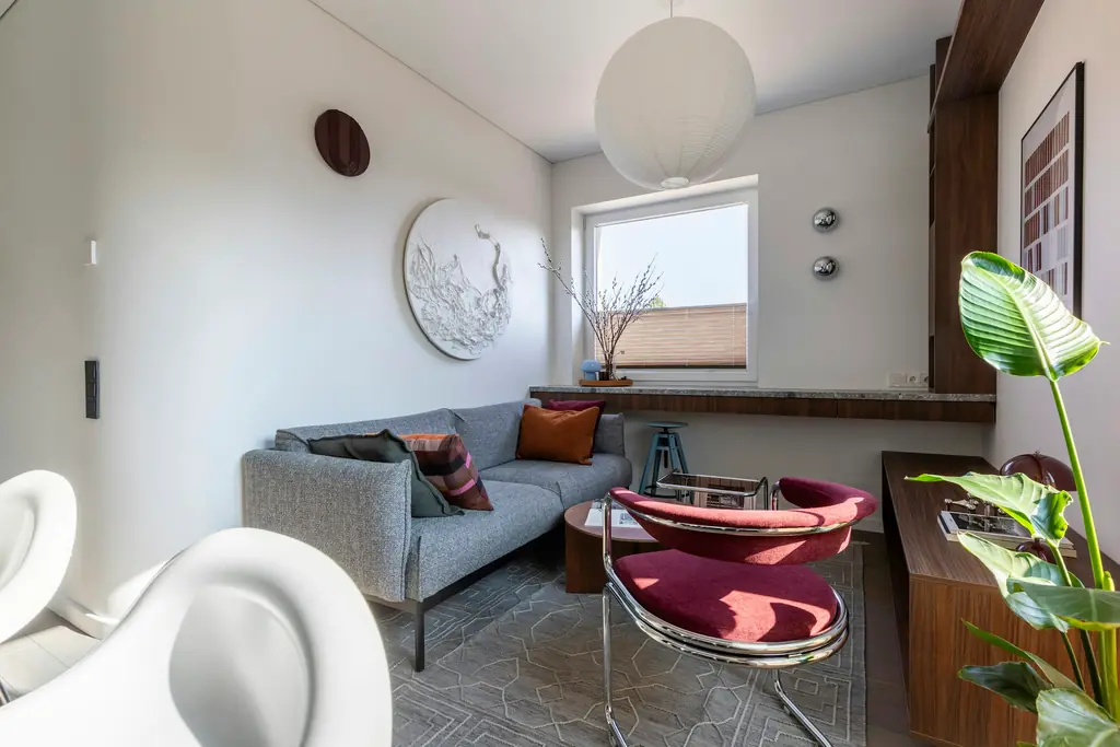 Salón con sofá gris y sillas de diseño