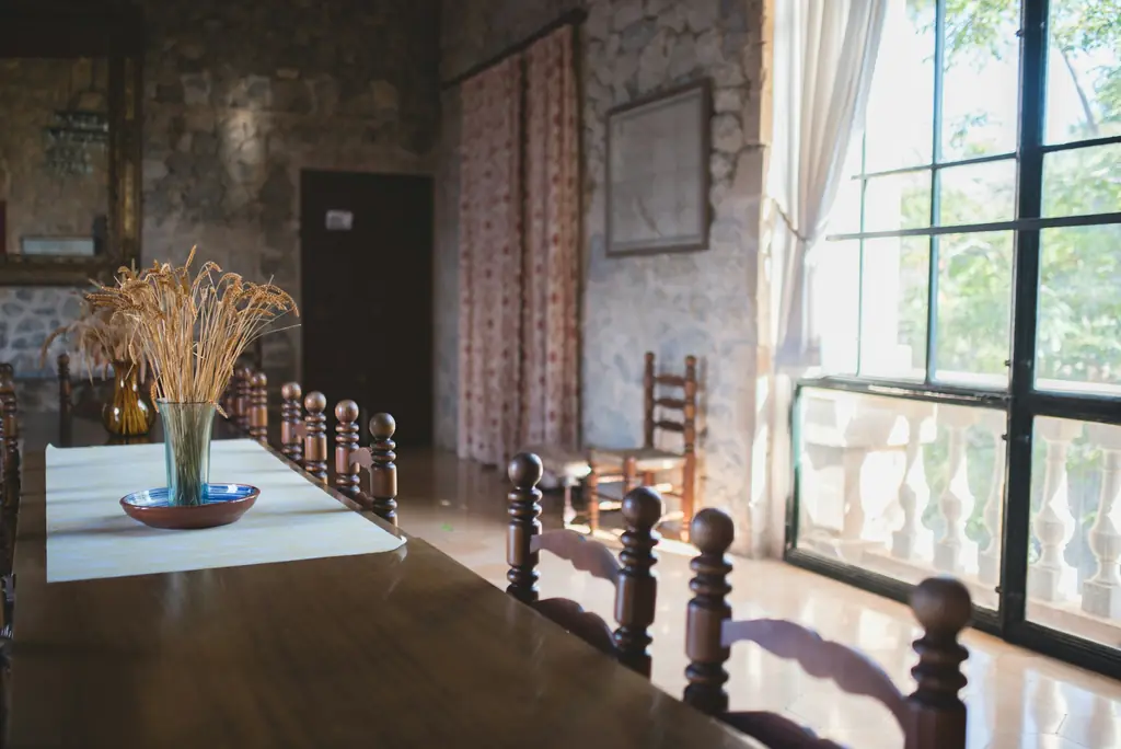 Comedor con mesa de madera y ventanal de hierro